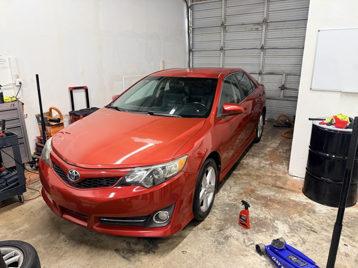Red Toyota sedan after detailing inside the Mirror Motion work area